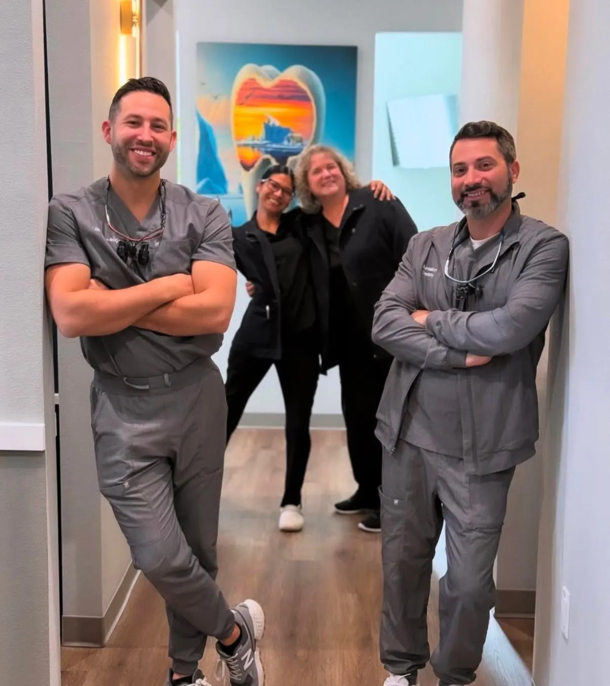 Dr. Brandon Wolf, Staff 1, Staff 2 and Dr. Noah Honig in the art-lined hallway of the Lutz office